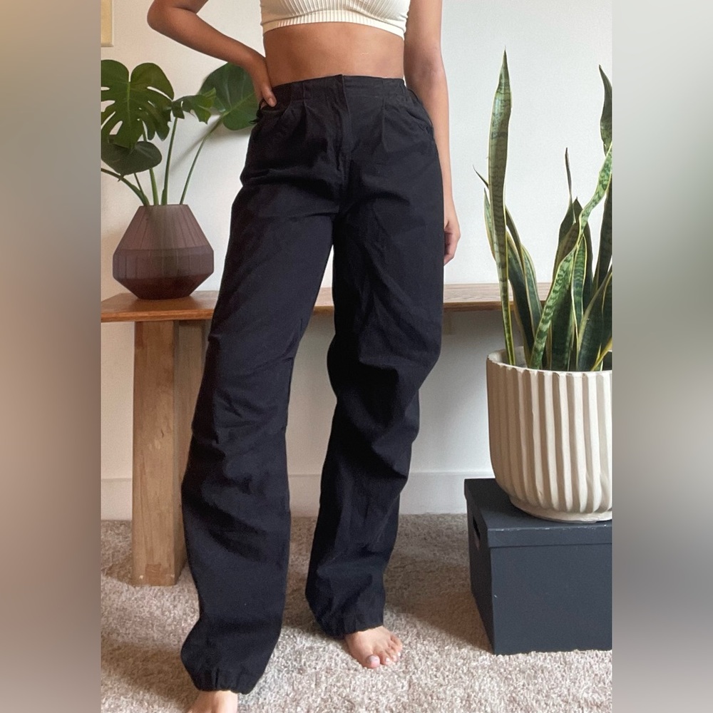 Black baggy parachute pants. Model is 5’0”- 110lbs for reference.